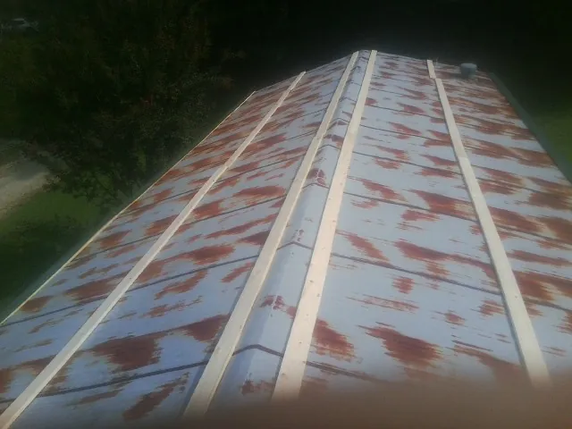 Rusted metal roof panels with new wood purlins before replacement — Storm Damage Roof Repair in Petrolia by Roofing Brothers