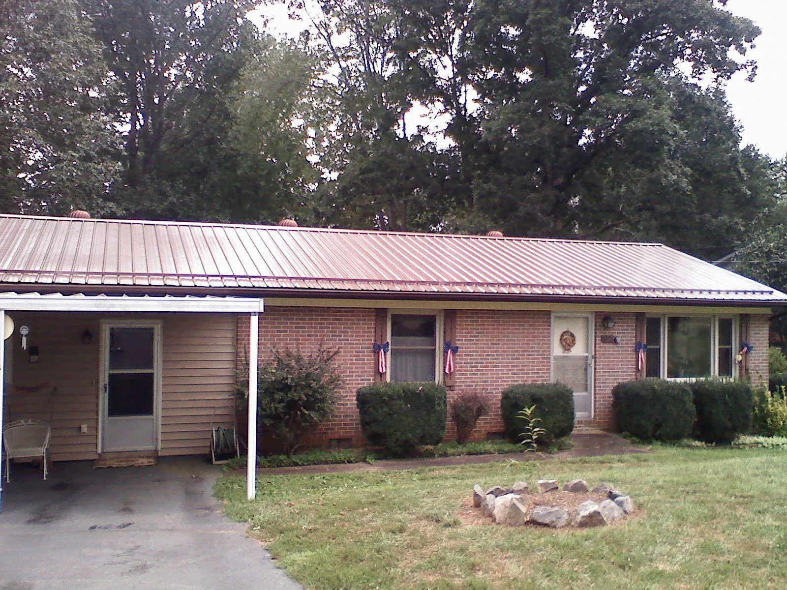 Bronze metal roof and carport on a brick ranch home — Roof Repair work by our crew in Petrolia